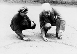 Free Picture of Man Showing a Boy How to Shoot Marbles