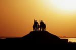 Free Picture of Soldiers and Children Silhouetted Against a Sunset