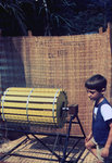Free Picture of Boy Standing Beside a Rice Threshing Machine at a 1976 Sierra Leone Lassa Fever Field Study